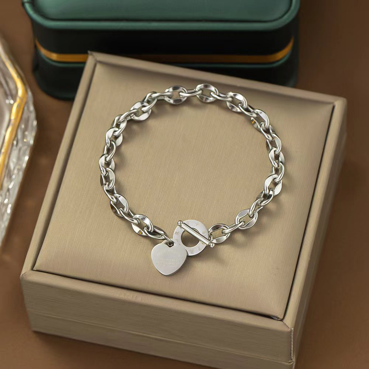 Brazalete Plateado de Cadena con un Dije de Corazón y un Cierre de Barra en T